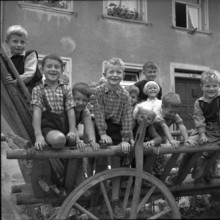 Büsingen; children sitting on wooden cart; 1955
