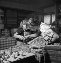 Women examining rag rugs, 1940