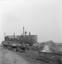 WW2: economy of war; inmates unloading used metal