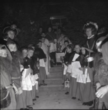 Children in historical costumes wait for Santa Claus in 1941