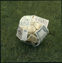 Golden football, having banknotes stuck all over