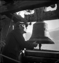 Man controlling church bells in village in Valais