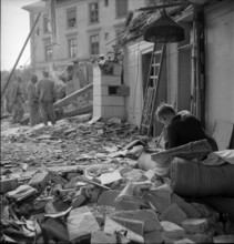 WW 2: bomb airdrop, dropping; young man in his demolished home, Schaffhausen 1944