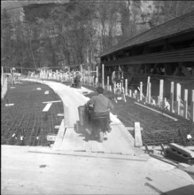 New Wynigen bridge under construction, next to the old wooden roofed bridge; 1960