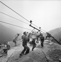Indemini, building material is unloaded from ropeway; 1960