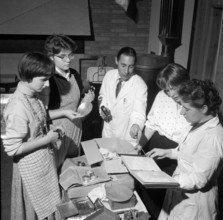 Young women and teacher discuss proceeding for creation of jewel
