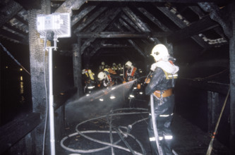 Fire extinguishing on the charred Chapel bridge 1993