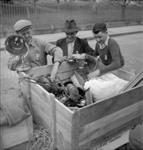 Men collecting nonferrous metal, handcart; 1942