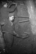 Miners in the tunnel; preparing the blast hole; 1942