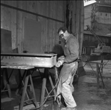 Construction site Oberaar, metalworker plastering a steel profile 1951