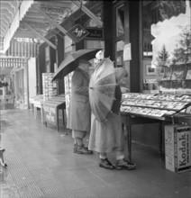 Grindelwald, couple looking at the display of a photo shop; 1950