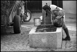 Hiker drinking water at a fountain, Switzerland 1971