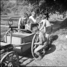 Children transporting peat briquettes; 1940
