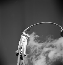Painter painting street lamp, 1949