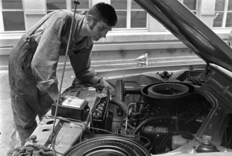 Car mechanic checks the engine; 1971