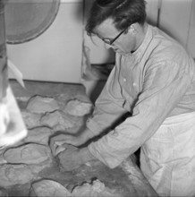 Baker shapes dough into bread; 1965