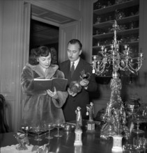 Auction, couple looking at exhibited items; 1950