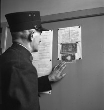 Official reads notice about counterfeit banknotes in circulation; 1943