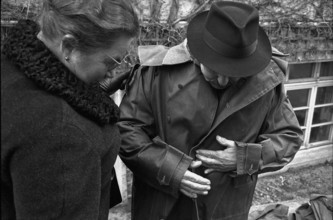 Thun, sale of used army equipment, man trying on army coat; 1969