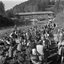 Children help move an old wooden bridge; 1952