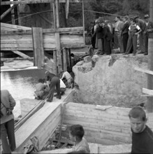 Children help move an old wooden bridge; 1952