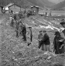 Men doing cleanup work in the Valais village of Täsch; 1957