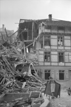 WW 2: bomb airdrop, dropping. woman in front of destroyed house, Schaffhausen 1944