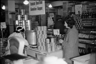Salesperson serving customer in a food shop. soup on offer. 1945