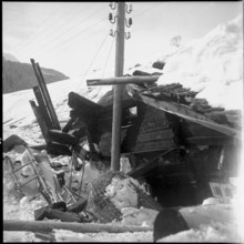 Vals, men searching for missing persons in the half of a building razed by avalanche, 1951