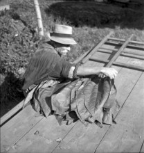 Man beading tobacco leaves, 1941