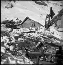 Urnerboden: people searching among the remains of buildings destroyed by an avalanche, 1940
