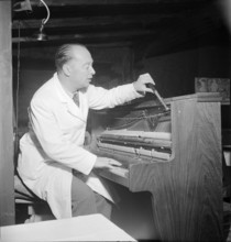 Davos: Piano tuner tuning a hotel piano; 1949