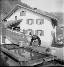 Woman washing clothes at the fountain, 1946