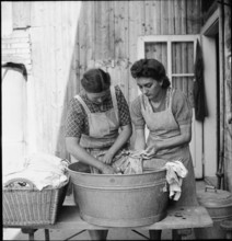 Young Swiss woman abroad helps with laundry; 1944