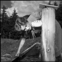 Girl Scout drinking water from a well, 1952