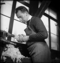 Preparations for the turnip lantern parade, man hollowing out a turnip with a machine, 1945