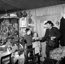 Farmer's family celebrates Christmas, postman brings gift package; 1960