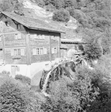 House with water wheel in Obersaxen, circa 1950