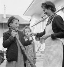 Boy receives a small reward for blowing the horn, 1944