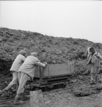 WW 2: economy of war; inmates pushing trolley, lorry.
