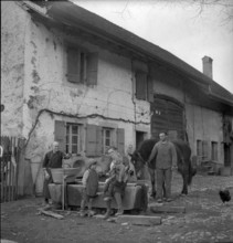 Goumoens-la-Ville: farmer family at fountain; 1949.