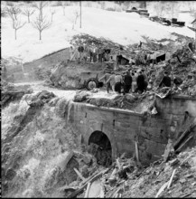 Avalanche in Nendaz, men recovering avalanche victim; 1957.