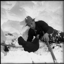 Avalanche in Spiringen, Schächen valley: man with rescued chicken; 1954.