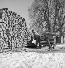 Woodcutter, pile of wood, 1943.