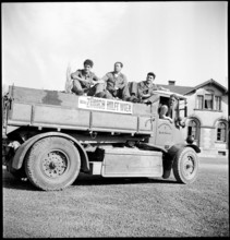 Men on truck to transport the collected potatoes.