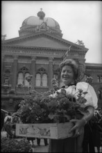 Woman with geranium in front of parliament building, Berne 1966.
