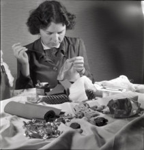 Woman making a Santa Claus doll in 1944.