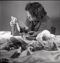Woman making a Santa Claus doll in 1944.