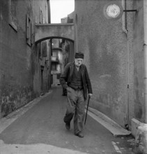 Grandvaux: old man using walking stick; 1948.