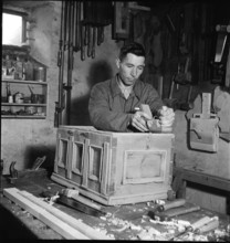Man planing part of a cupboard, 1946.